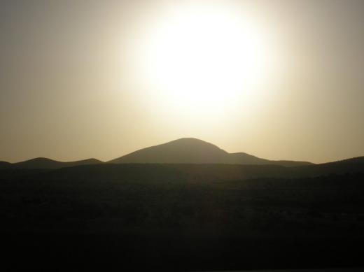 Sun over the 7000' mountain, Desert road, NM